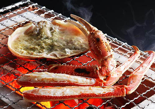 写真:網の上で焼く松葉かに