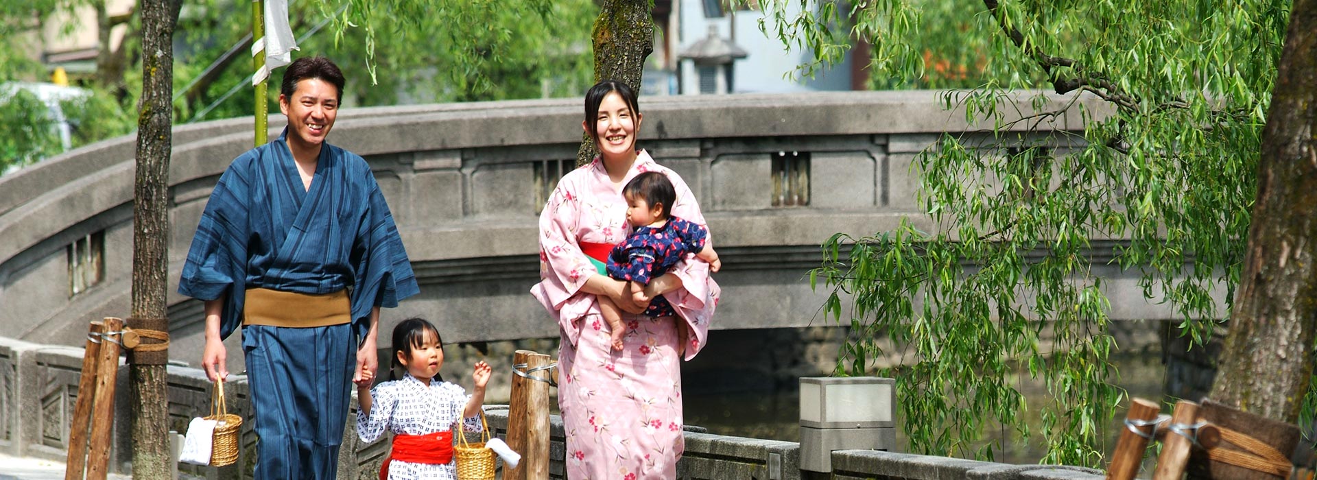 Photo: A family of four with two children touring the outside hot springs of Kinosaki Onsen